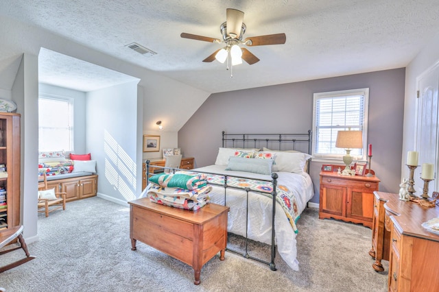 bedroom with ceiling fan, light colored carpet, a textured ceiling, and lofted ceiling