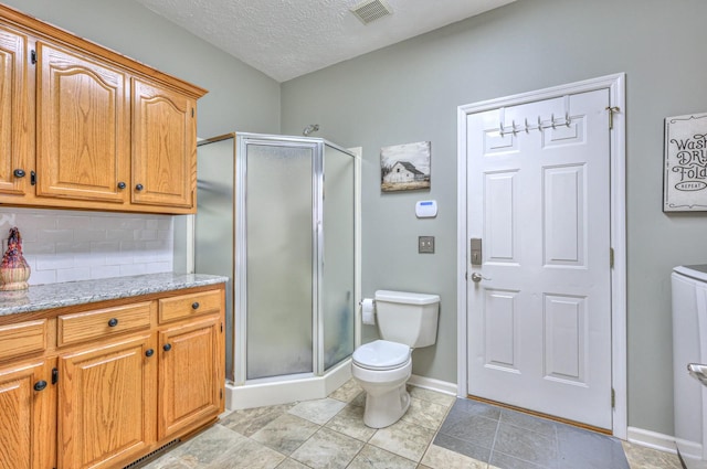 bathroom with toilet, a textured ceiling, decorative backsplash, and a shower with door