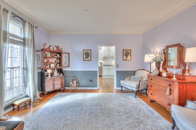 sitting room featuring light wood-type flooring and crown molding