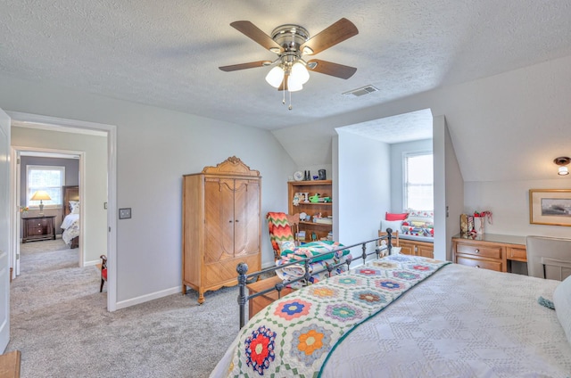 bedroom with ceiling fan, light carpet, a textured ceiling, and lofted ceiling