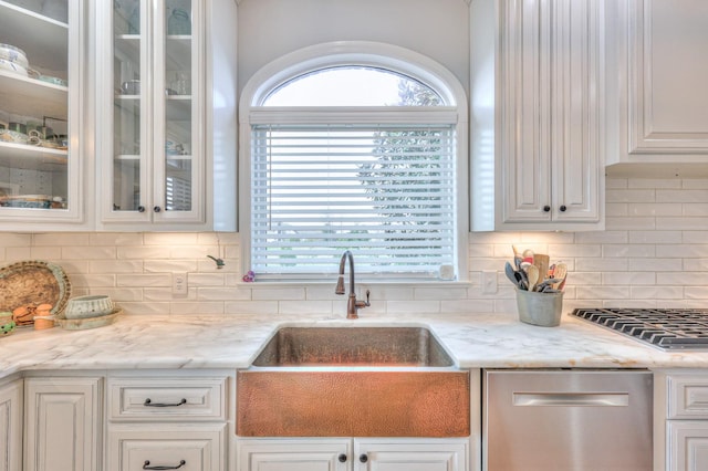 kitchen featuring light stone counters, sink, white cabinets, and appliances with stainless steel finishes