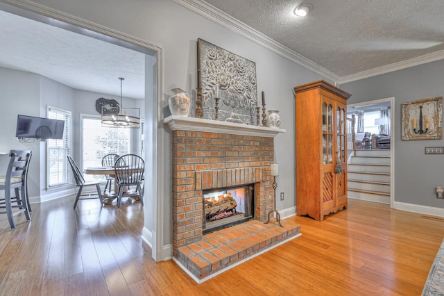 living room with a brick fireplace, a textured ceiling, wood-type flooring, and a wealth of natural light