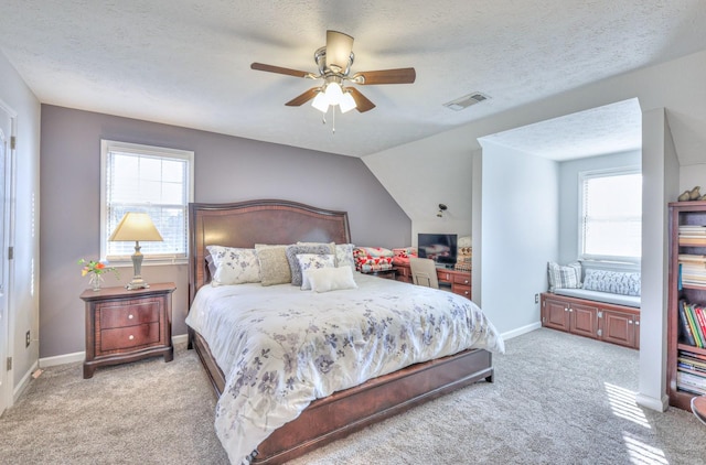 bedroom featuring light carpet, ceiling fan, vaulted ceiling, and a textured ceiling