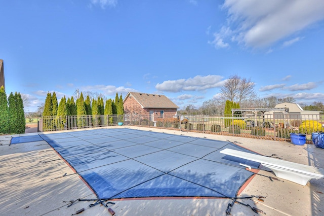 view of swimming pool featuring a diving board