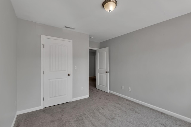 unfurnished bedroom featuring light colored carpet and a closet