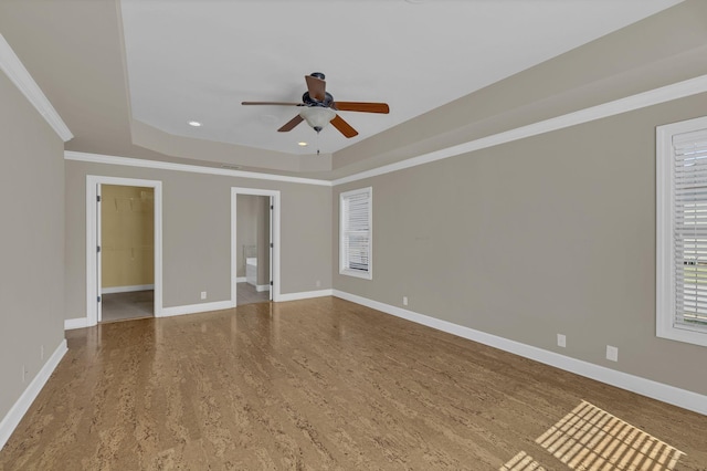 unfurnished room with ceiling fan, a tray ceiling, ornamental molding, and hardwood / wood-style floors