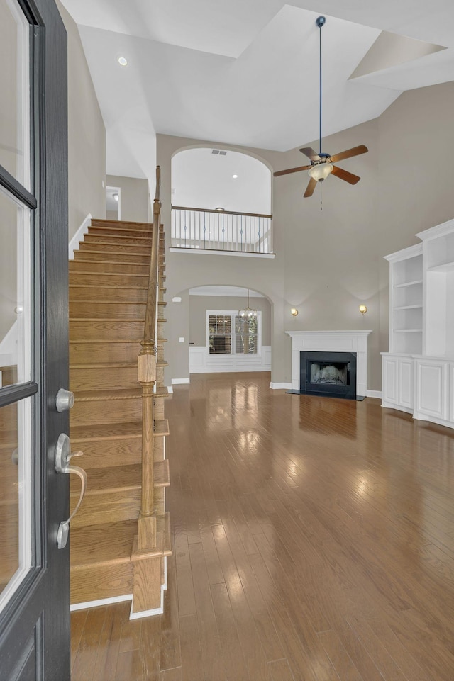 unfurnished living room featuring ceiling fan, hardwood / wood-style floors, and high vaulted ceiling