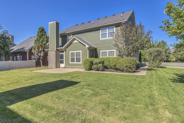 back of property featuring a patio area and a lawn