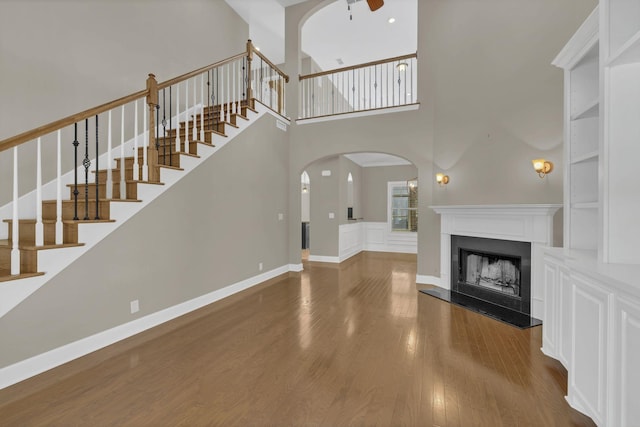 unfurnished living room featuring a towering ceiling and hardwood / wood-style floors