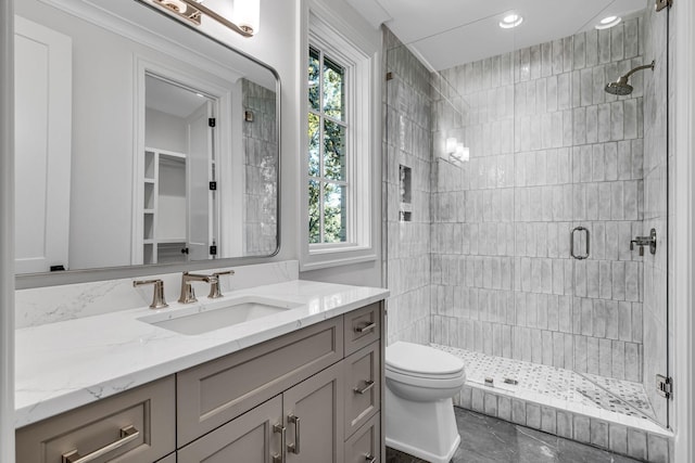 bathroom featuring walk in shower, vanity, tile patterned floors, and toilet