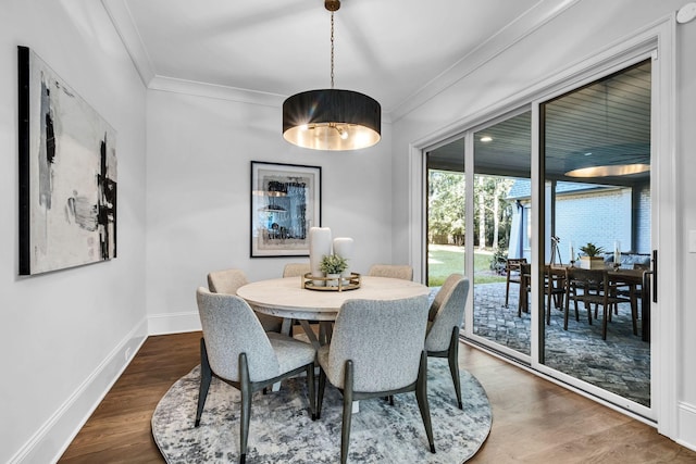 dining space with dark wood-type flooring and ornamental molding