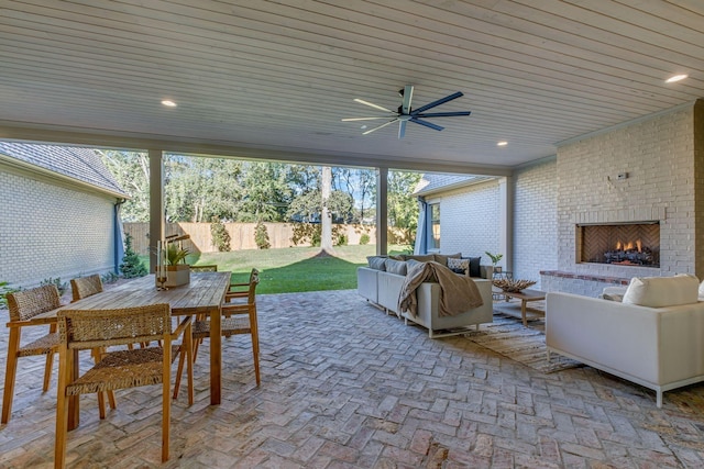 view of patio featuring ceiling fan and an outdoor living space with a fireplace