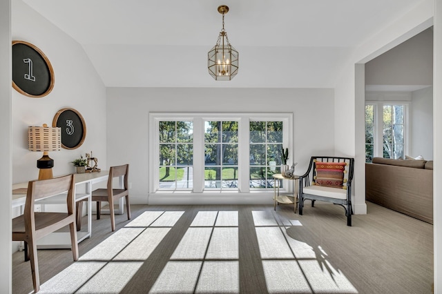 living area with a chandelier and lofted ceiling