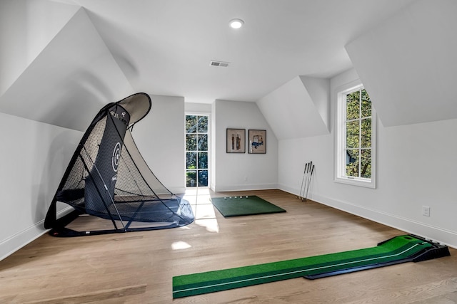 exercise room featuring vaulted ceiling and hardwood / wood-style flooring