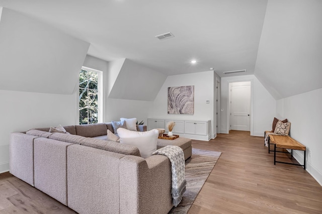 living room featuring lofted ceiling and light hardwood / wood-style floors