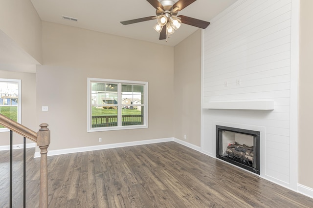 unfurnished living room with dark wood-type flooring, a fireplace, and ceiling fan