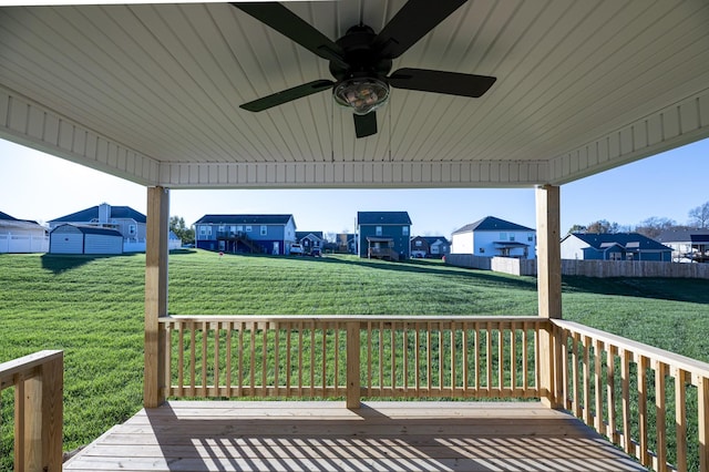 wooden deck with ceiling fan and a lawn