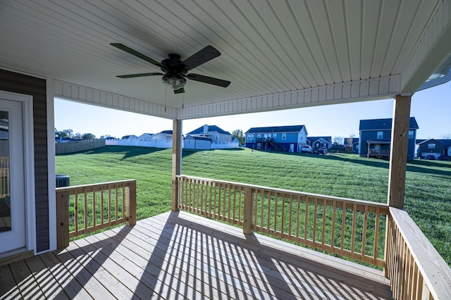 wooden deck featuring ceiling fan and a lawn