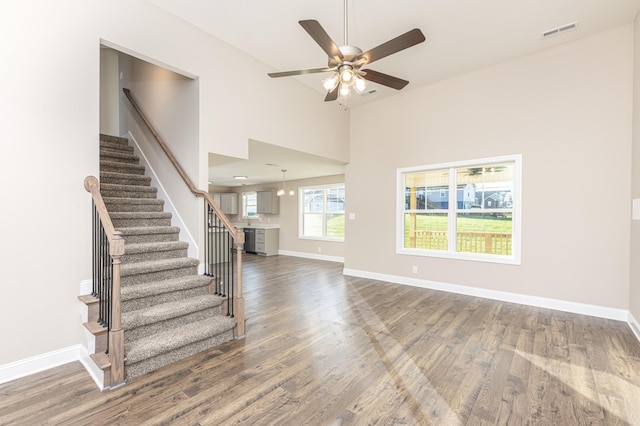 interior space with ceiling fan, a high ceiling, and hardwood / wood-style floors