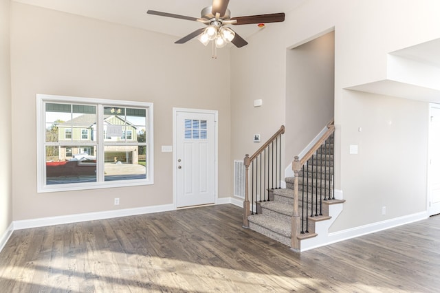 foyer with ceiling fan, dark hardwood / wood-style flooring, and a high ceiling