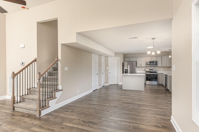 kitchen with gray cabinets, appliances with stainless steel finishes, dark wood-type flooring, pendant lighting, and sink