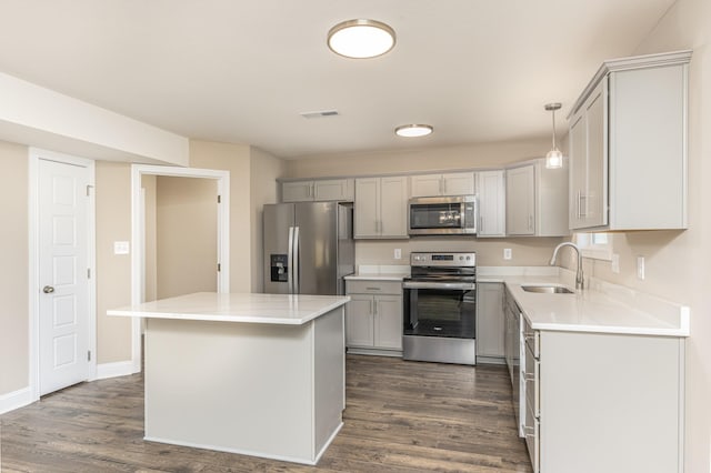 kitchen with pendant lighting, a center island, stainless steel appliances, sink, and gray cabinetry