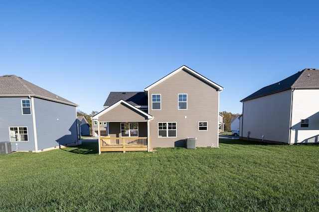 rear view of property featuring a deck, cooling unit, and a yard