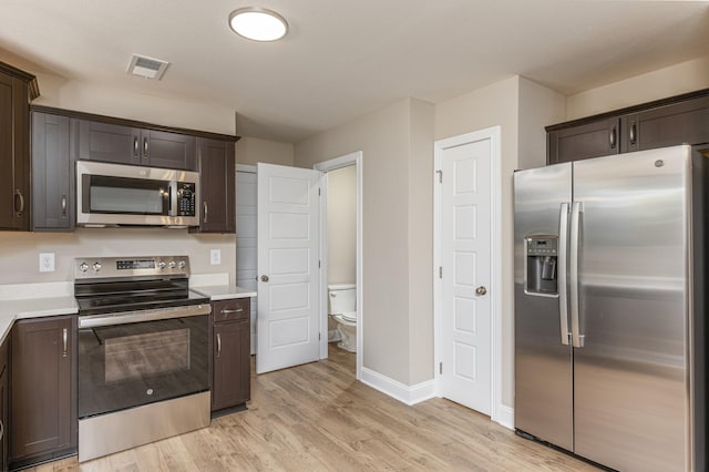 kitchen featuring dark brown cabinetry, light hardwood / wood-style floors, and appliances with stainless steel finishes