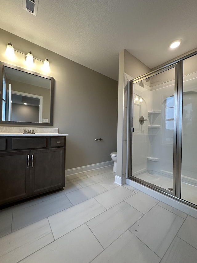 bathroom with vanity, toilet, a textured ceiling, and walk in shower