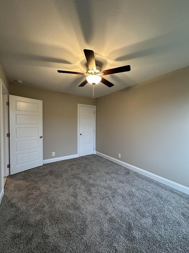 unfurnished bedroom featuring ceiling fan, a textured ceiling, and dark colored carpet