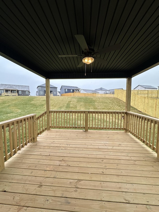 wooden terrace with ceiling fan and a yard