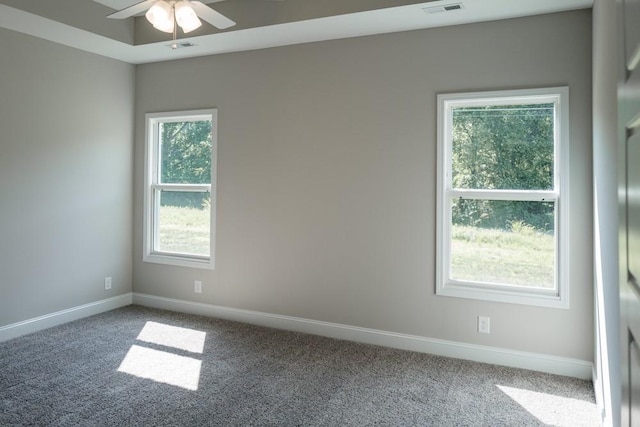 carpeted spare room featuring ceiling fan and a healthy amount of sunlight