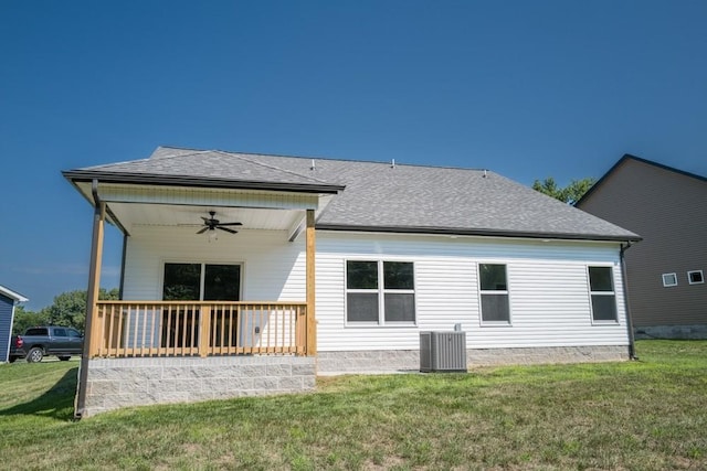 back of house with ceiling fan, central AC unit, and a lawn