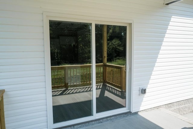 doorway to outside featuring concrete floors and wooden walls