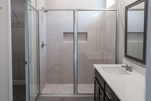 bathroom with a shower with shower door and vanity