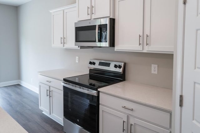 kitchen featuring dark hardwood / wood-style floors, stainless steel appliances, and white cabinets