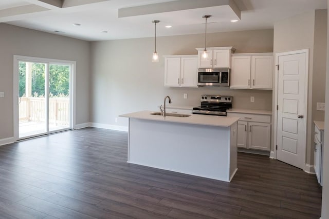 kitchen featuring a center island with sink, sink, hanging light fixtures, appliances with stainless steel finishes, and white cabinets