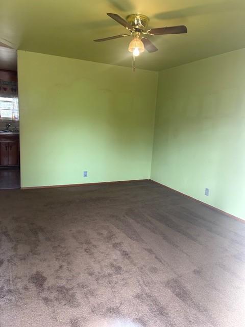 carpeted empty room featuring ceiling fan and sink