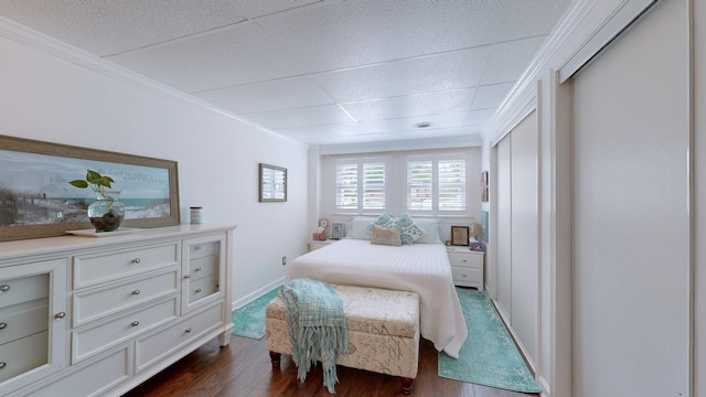 bedroom with ornamental molding and dark hardwood / wood-style floors