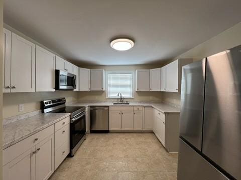 kitchen with white cabinets, sink, and stainless steel appliances