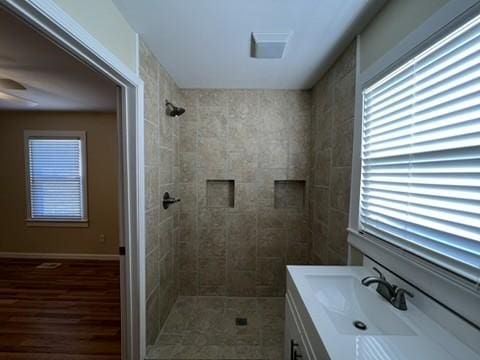 bathroom featuring vanity and tiled shower