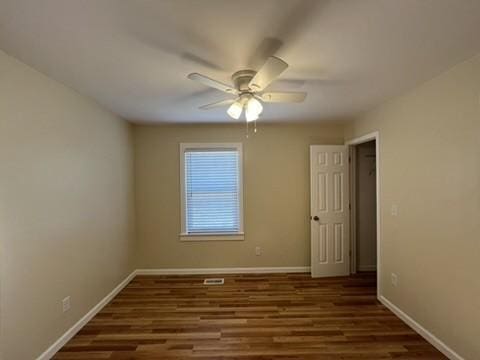 spare room with ceiling fan and dark hardwood / wood-style floors