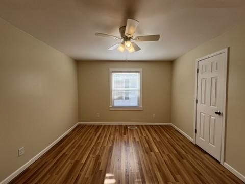 spare room with ceiling fan and dark hardwood / wood-style flooring