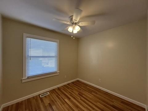 unfurnished room with ceiling fan and dark hardwood / wood-style flooring