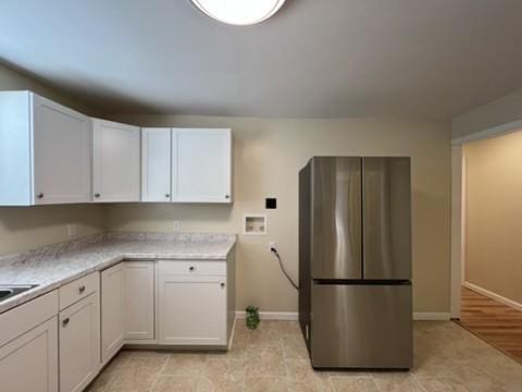 kitchen featuring white cabinets and stainless steel fridge