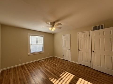 unfurnished bedroom featuring ceiling fan and dark wood-type flooring