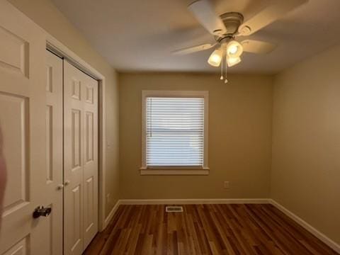 spare room featuring ceiling fan and dark wood-type flooring