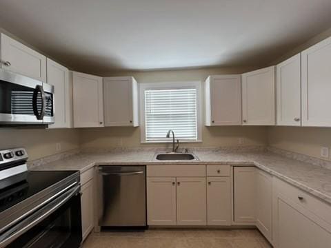 kitchen with sink, white cabinetry, and stainless steel appliances