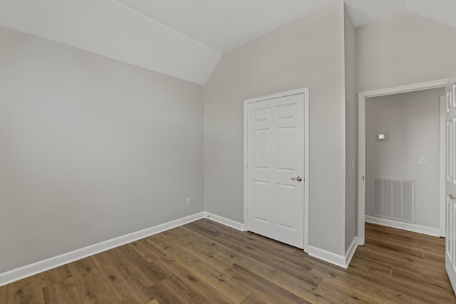 interior space with vaulted ceiling and dark hardwood / wood-style floors