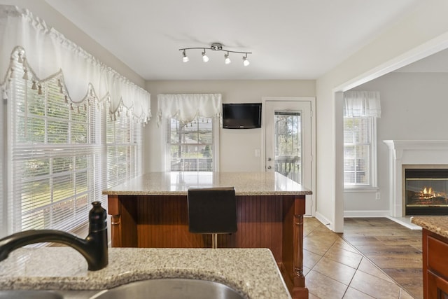 kitchen with light stone countertops, sink, and tile patterned floors